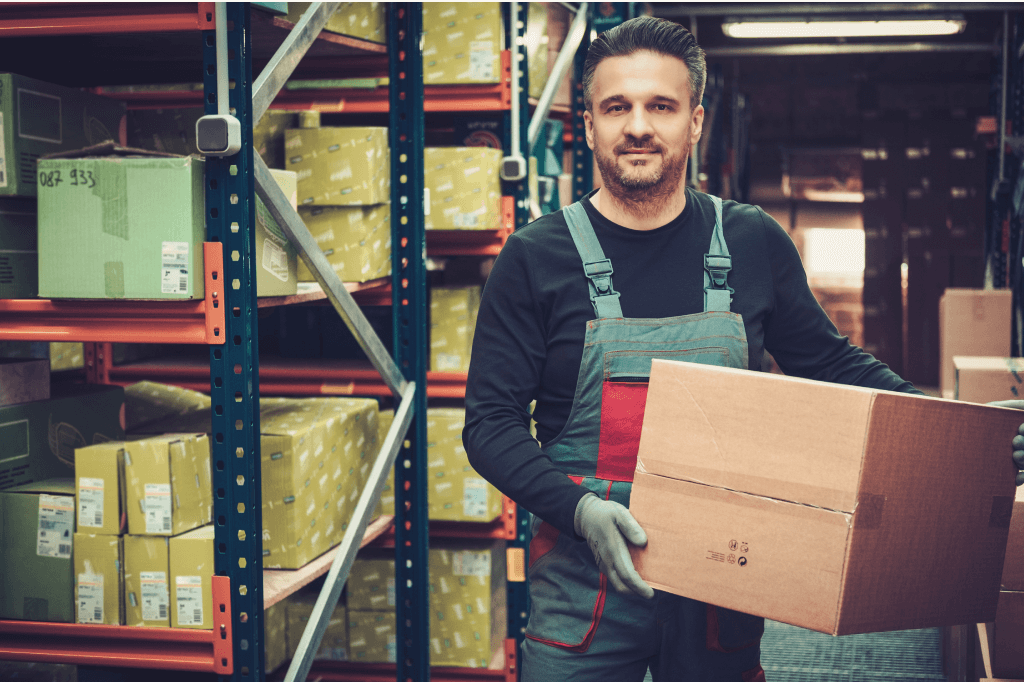 Person holding a box in a warehouse.