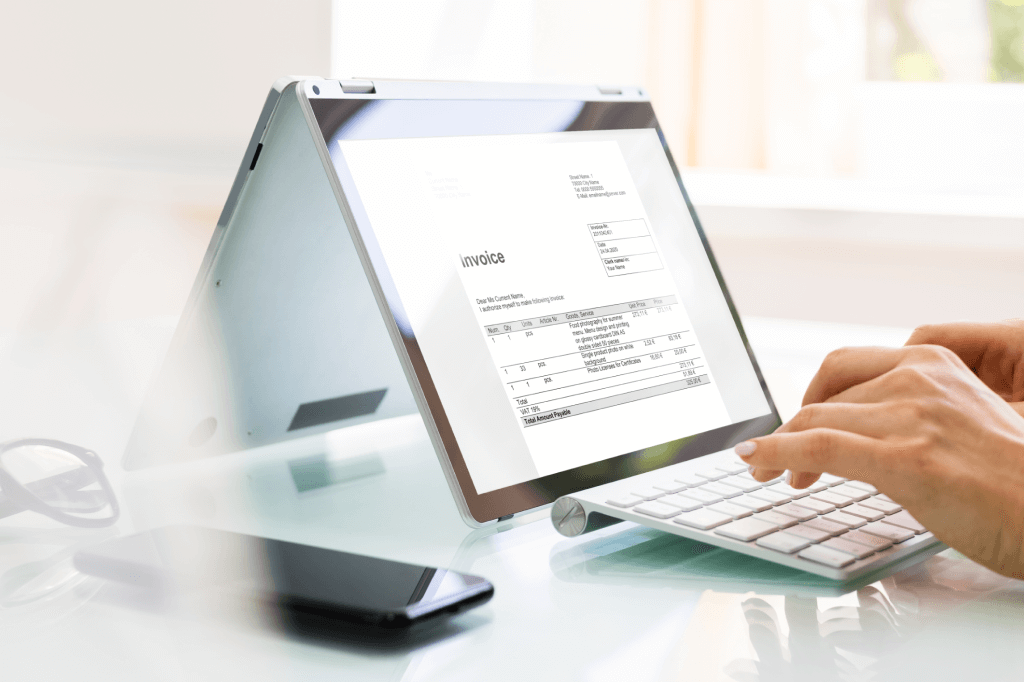 Person filling in an invoice on a computer.