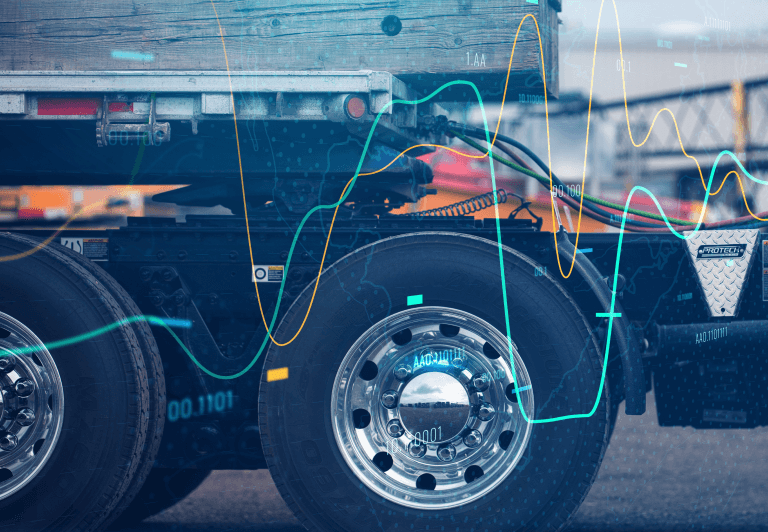 Close-up of fifth-wheel section and tires from the side with trailer connected.