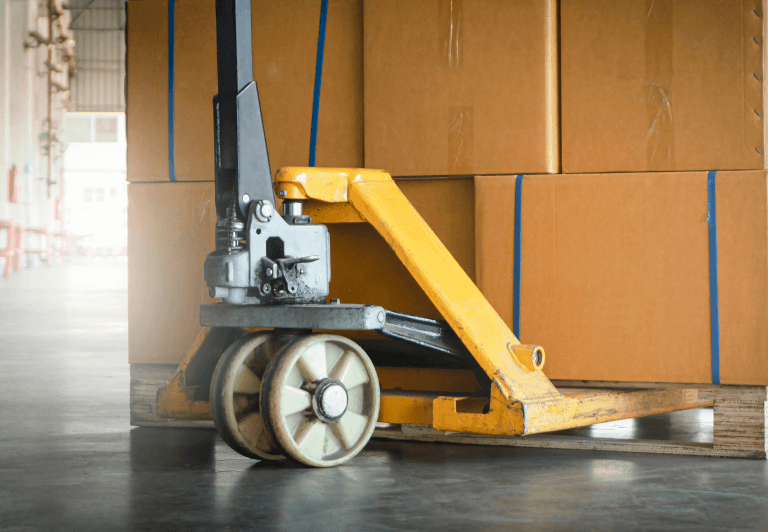 a pallet jack positioned to move a pallet of boxes.