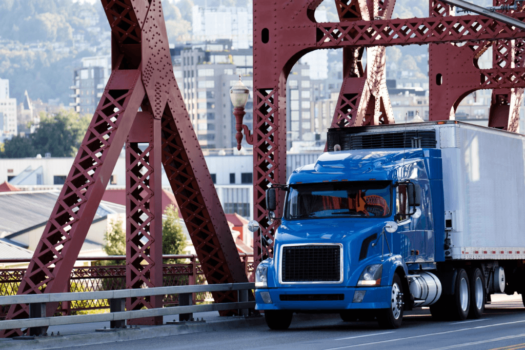truck and trailer driving on steel bridge