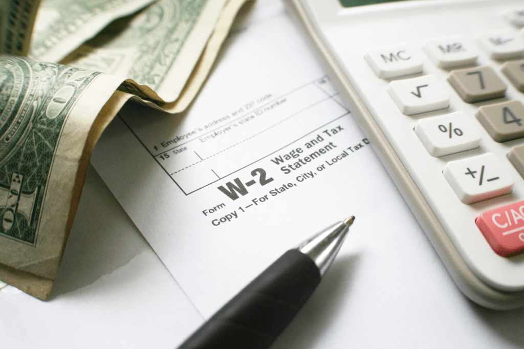 close up view of w-2 form calculator and dollar bills