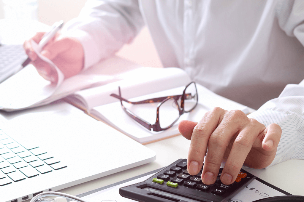 A person reviewing document and using a calculator. 