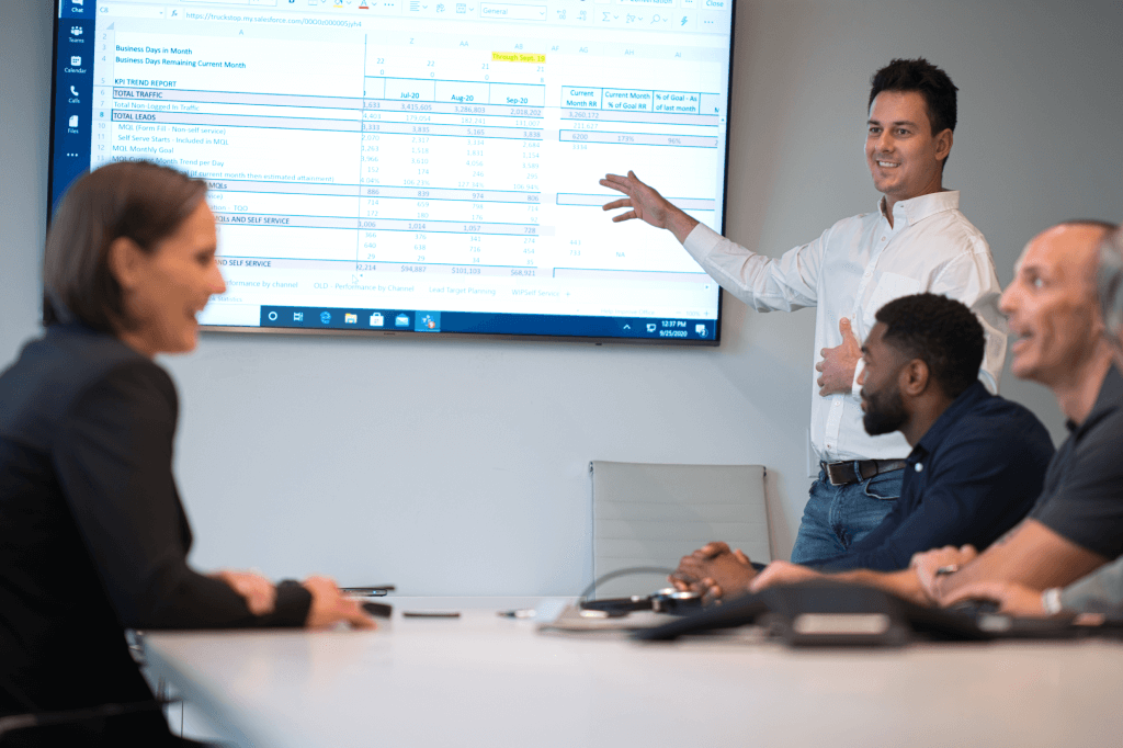 people in conference room looking at onscreen presentation