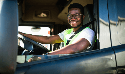 Driver smiling in cab of truck.